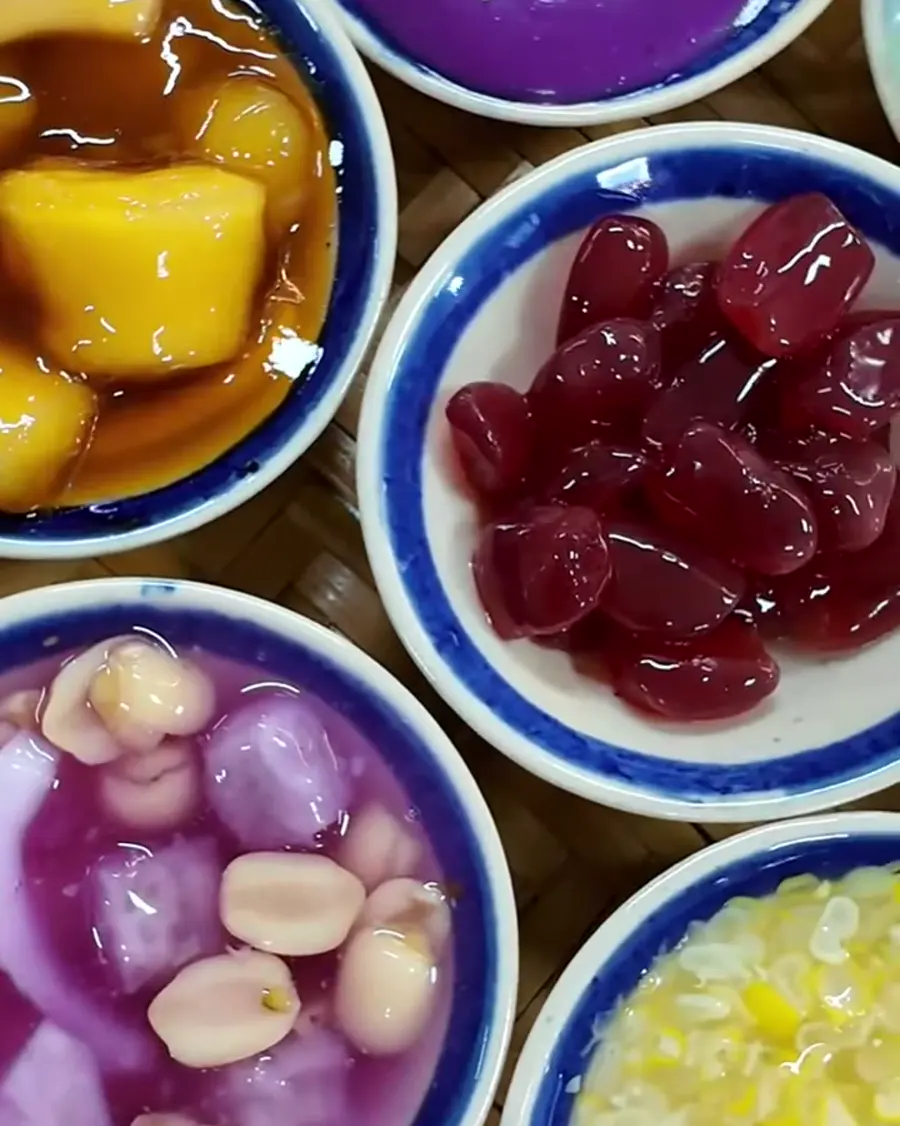 Mâm chè Hami nhìn từ trên xuống: nhiều chén chè nhỏ đủ màu trên mẹt tre ở quán chè HAMICHEE Nha Trang